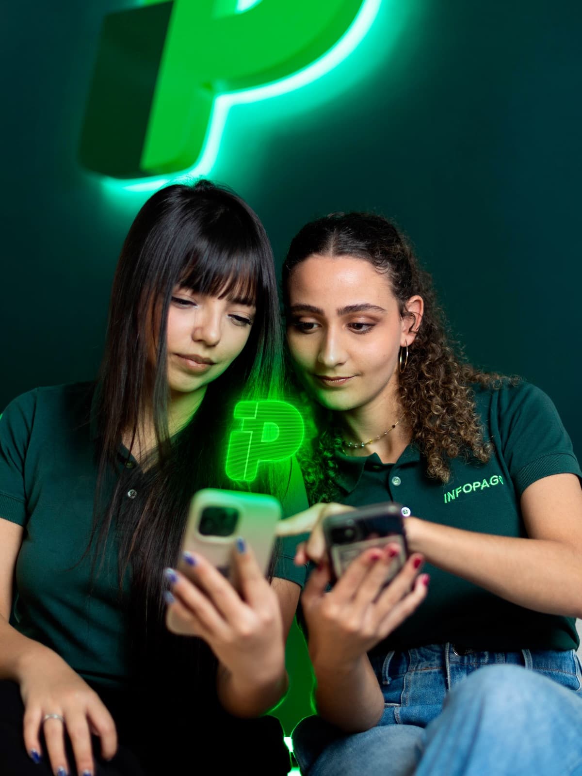 Duas mulheres conferindo o app da Infopago no celular